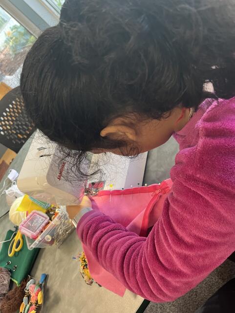 Student sewing with sewing machine. 