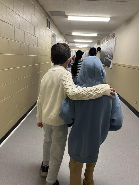 students walking arm in arm down the hallway