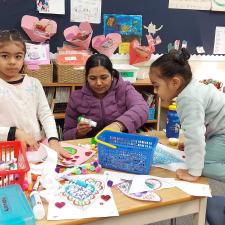 Female Parent doing arts and crafts with two young female students
