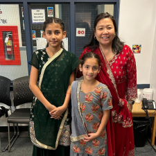 Two students and a teacher dressed in traditional attire to celebrate Diwali