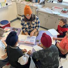 students participating in literacy instruction with teacher around a table