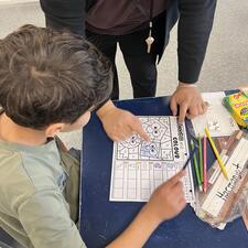 EA supporting student with literacy activity