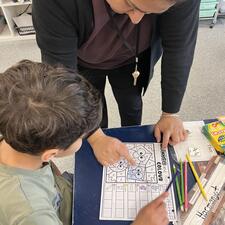 EA supporting student with literacy activity